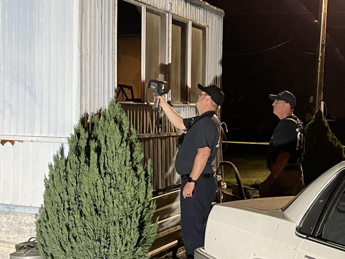 Capt. Kevin Sells of Benton County Fire District 1 uses a heat detector to identify possible hot spots inside a mobile home after a fire Saturday night that left one person dead.