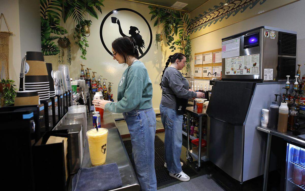 Kennah Rodriguez, left, and her sister, Ava, fill drink orders recently at the Java Lava Joe drive-thru coffee shop they recently started operating on Columbia Drive in Kenewick.