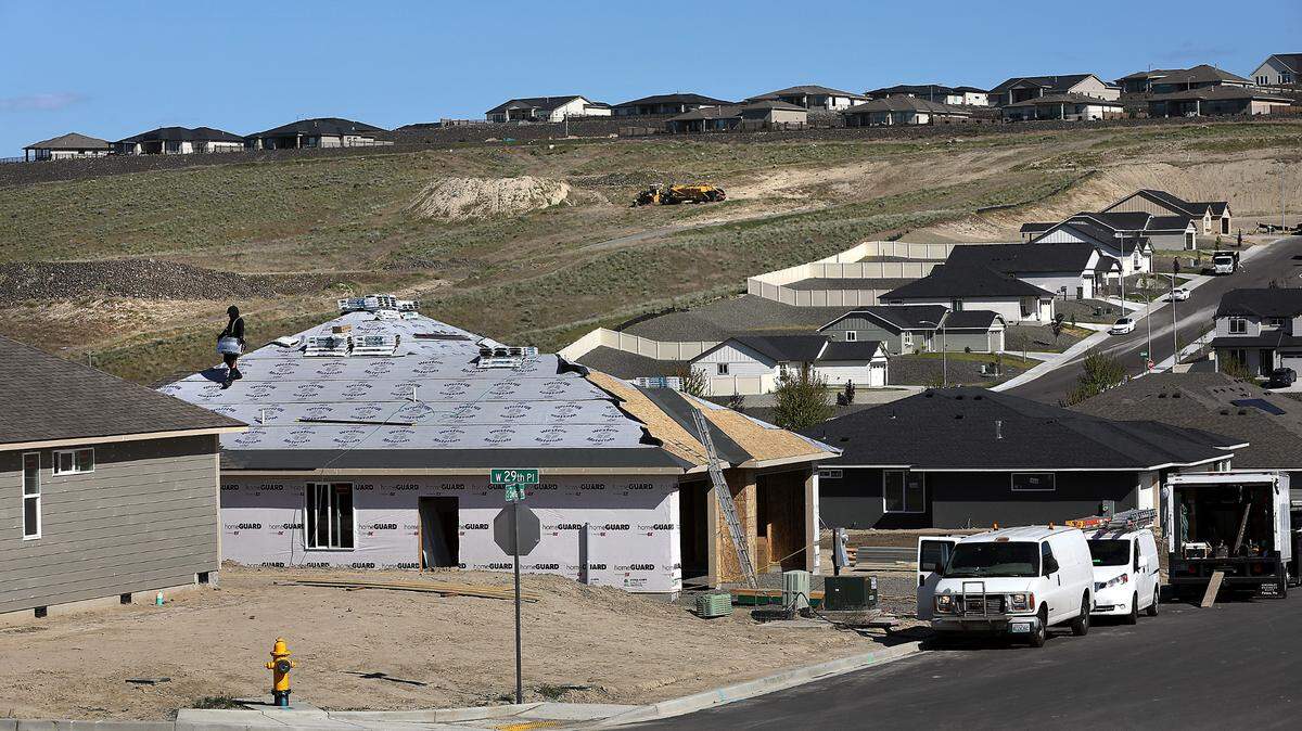 A roofer works on a new home under construction in the new Apple Valley housing development off the Bob Olson Parkway in the Southridge area of Kennewick.