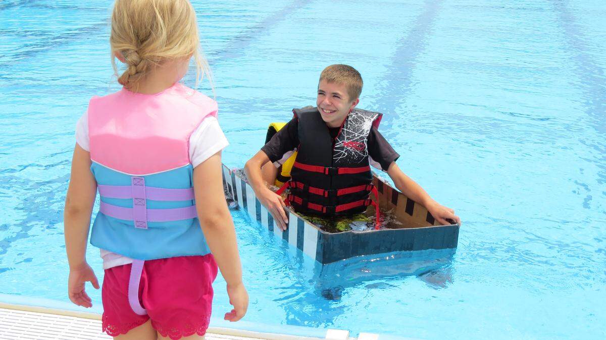 McCarty Kubalek, 12, nears the end of the Memorial Park swimming pool in his cardboard boat. He was one of about 10 participants in Pasco's Cardboard Regatta. The event was one of several taking place as part of the city's Grand Old 4th of July celebration. People made boats using cardboard, plastic bottles and other items. Some of the more creative designs included a replica of the Flintstones car and a viking boat.