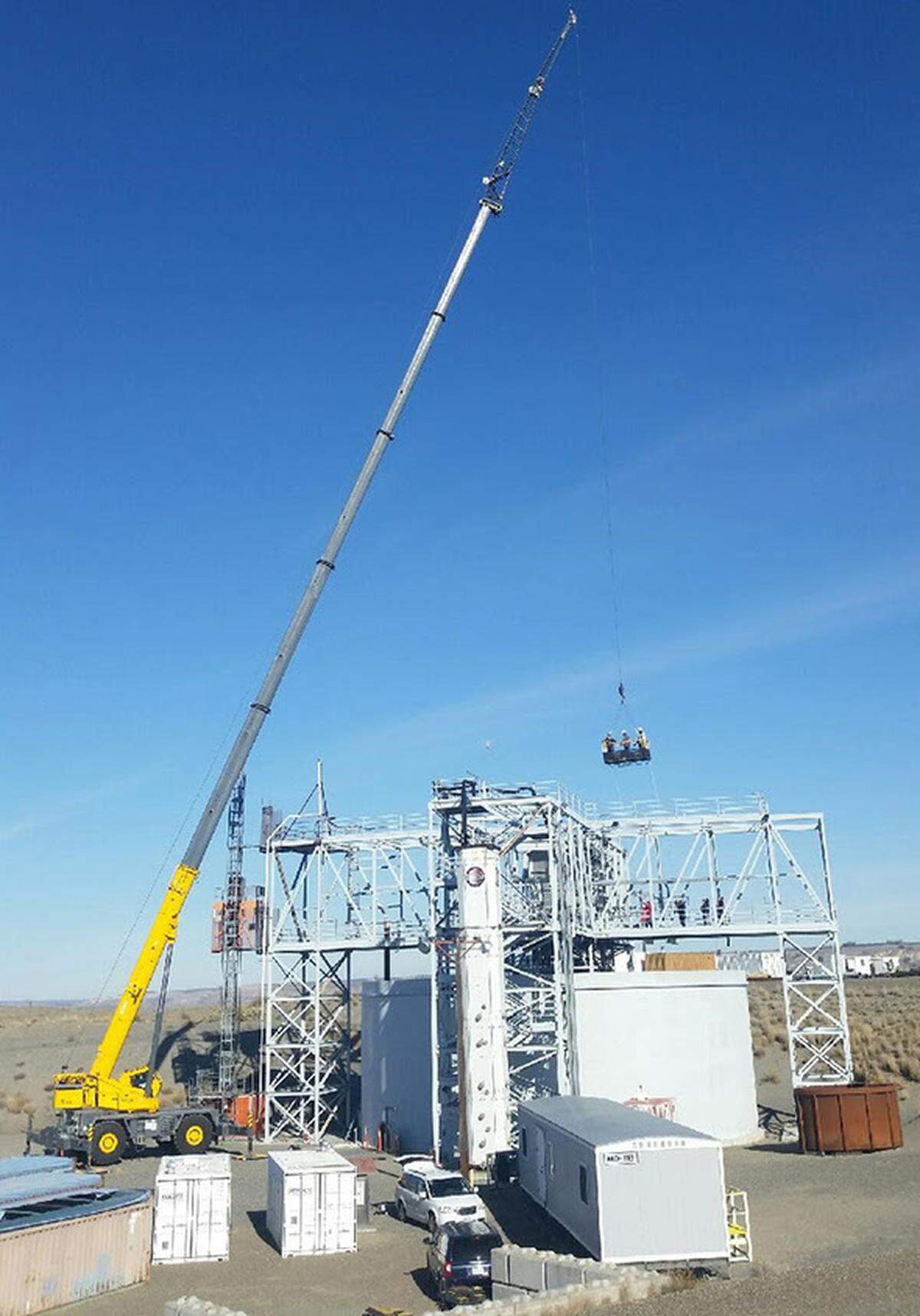 A Mission Support Alliance crane operator uses a 150-ton crane and a 256-foot extension to lift iron workers and electricians at the Hanford Site Cold Test Facility.