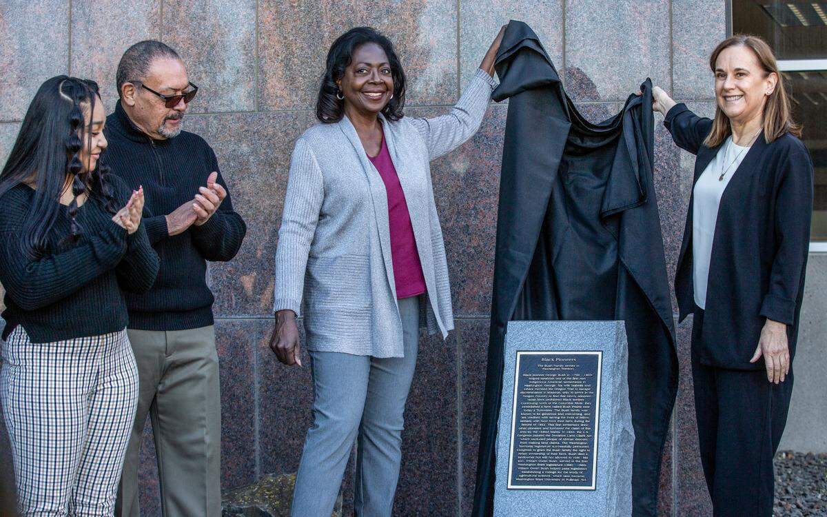 A new monument commemorating George Bush, the first Black pioneer in Washington Territory, and his son William Owen Bush, who served in the first legislature, was dedicated at WSU Tri-Cities on Tuesday in celebration of Black History Month. Aaliyha Dickerson, with the Black Student Union, and Leonard and Vanessa Moore, with the African American Community Cultural and Educational Society, joined Chancellor Sandra Haynes in the unveiling.