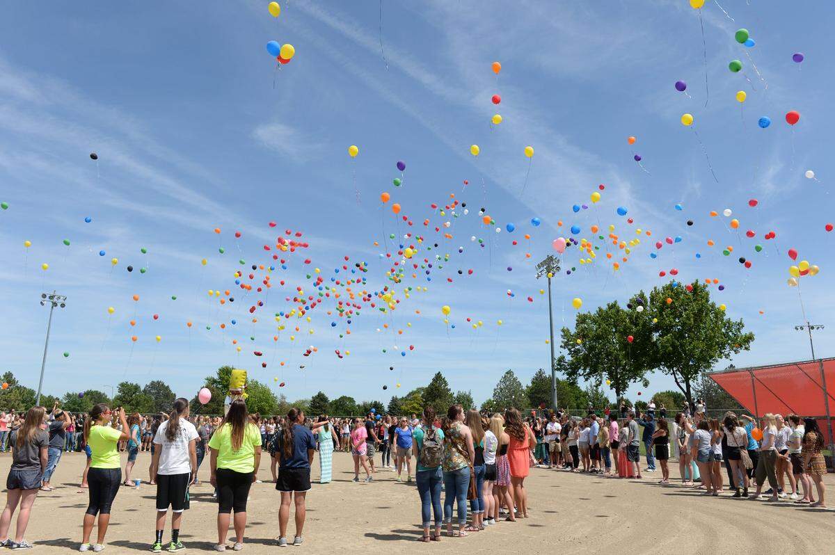 A few hundred people gathered at Lawrence Scott Field in Kennewick to release balloons in memory of Kate and Ethan Austin. Ethan, 12, killed his sister and then himself, say police.