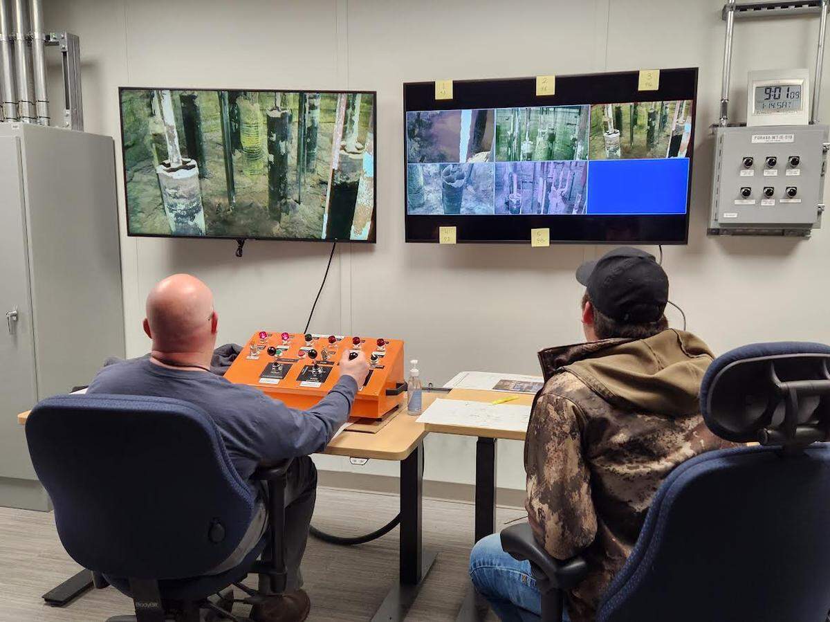 Workers use five cameras lowered inside Tank AX-101 on the Hanford site to monitor activity as they remotely start a sluicer to empty waste from the tank.