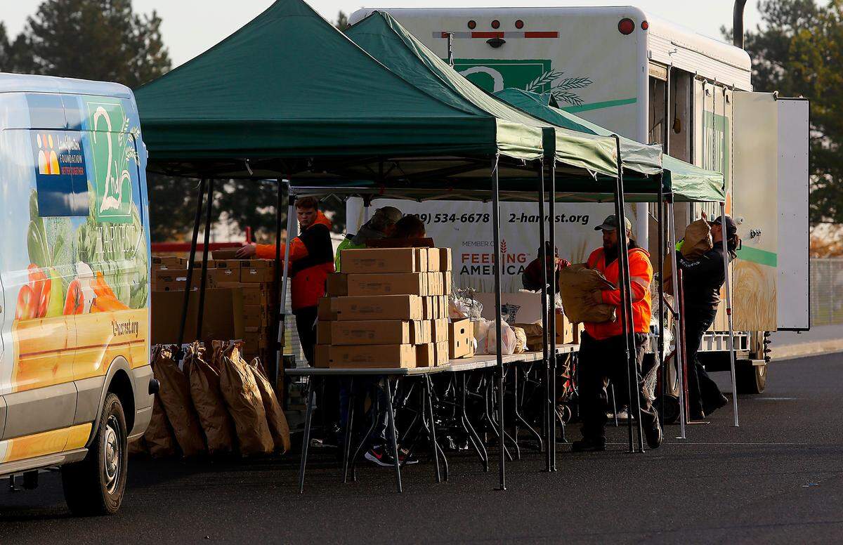 Workers unload boxes and bags of food bags in preparation for the start of the 2nd Harvest Mobile Market food distibution.
