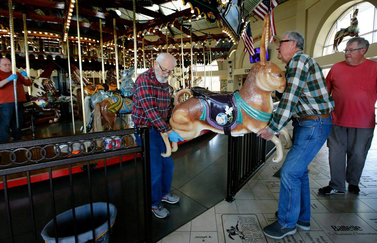Volunteer Pat Nagle and artist Mike Thornton carry the new Easter bunny carving into place for installation at the Gesa Carousel of Dreams in Kennewick. 