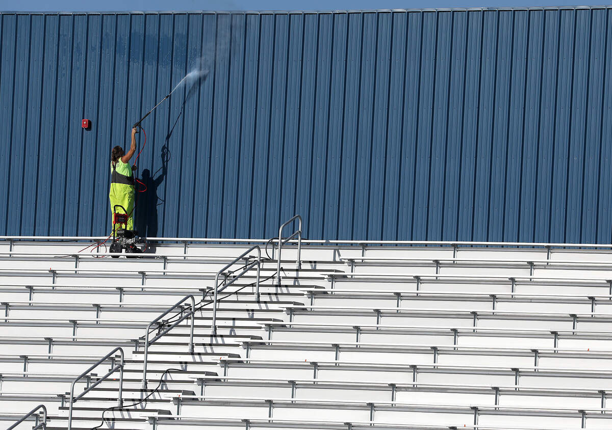 A construction worker uses a pressure spayer to clean the shade wall installed during the construction of the new $12 million grandstands structure built at the McDaniel rodeo arena at the Benton County Fairgrounds in Kennewick.