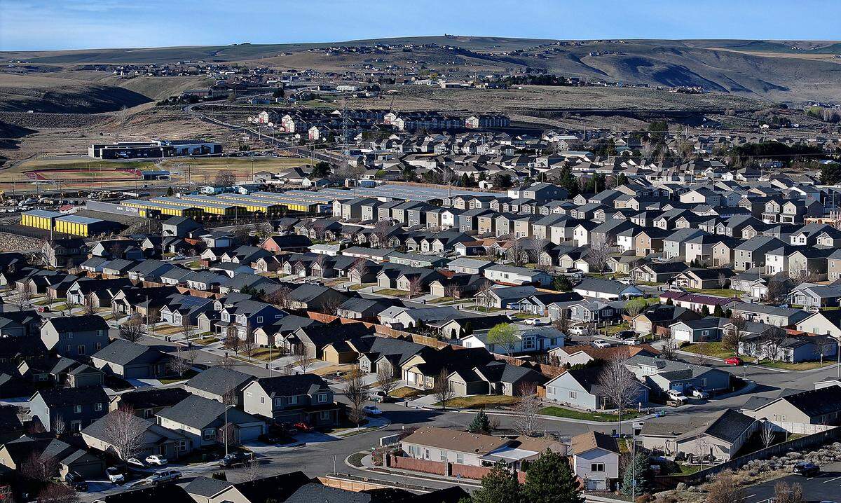 Drone photo of west Kennewick housing with apartments and Desert Hills Middle School and the Horse Heaven Hills in the background..