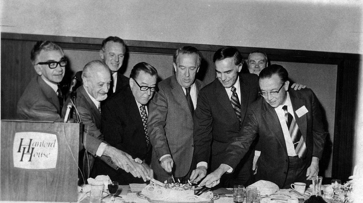 From left, Bob Philip, Sam Volpentest, Clif Lahue, Sen. Warren G. Magnuson, Sen. Henry Jackson, Gov. Dan Evans, Glenn C. Lee (in rear) and Jim Ramey, Atomic Energy Commissioner, cut a cake for the Tri­-City Nuclear Industrial Council in this 1970s photo. The economic development organization is now called the Tri-City Development Council, or TRIDEC.