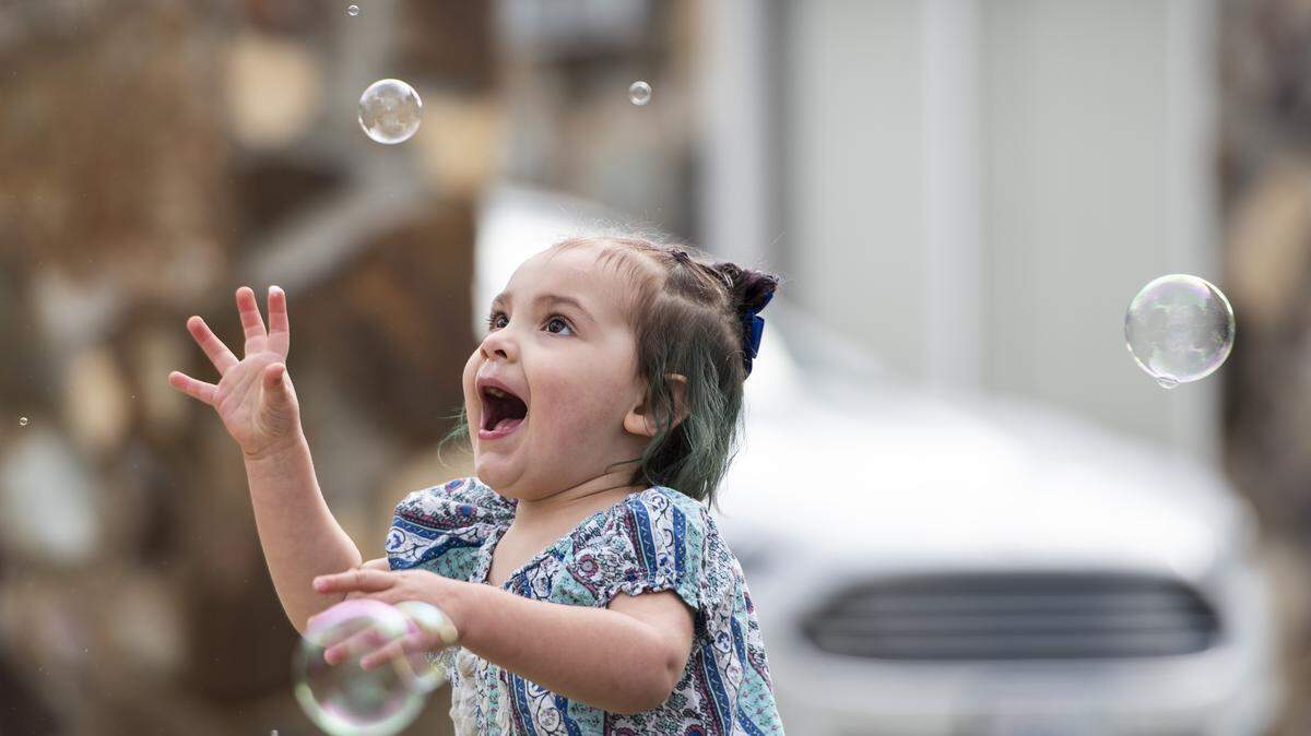 Makenzie Barios, 2, shrieks in delight while playing with bubbles during some outdoor time in her yard in Kennewick on April 2.