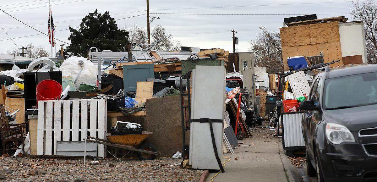 The public sidewalk in front of 2100 Pullen St. is partially blocked by junk and debris. 
