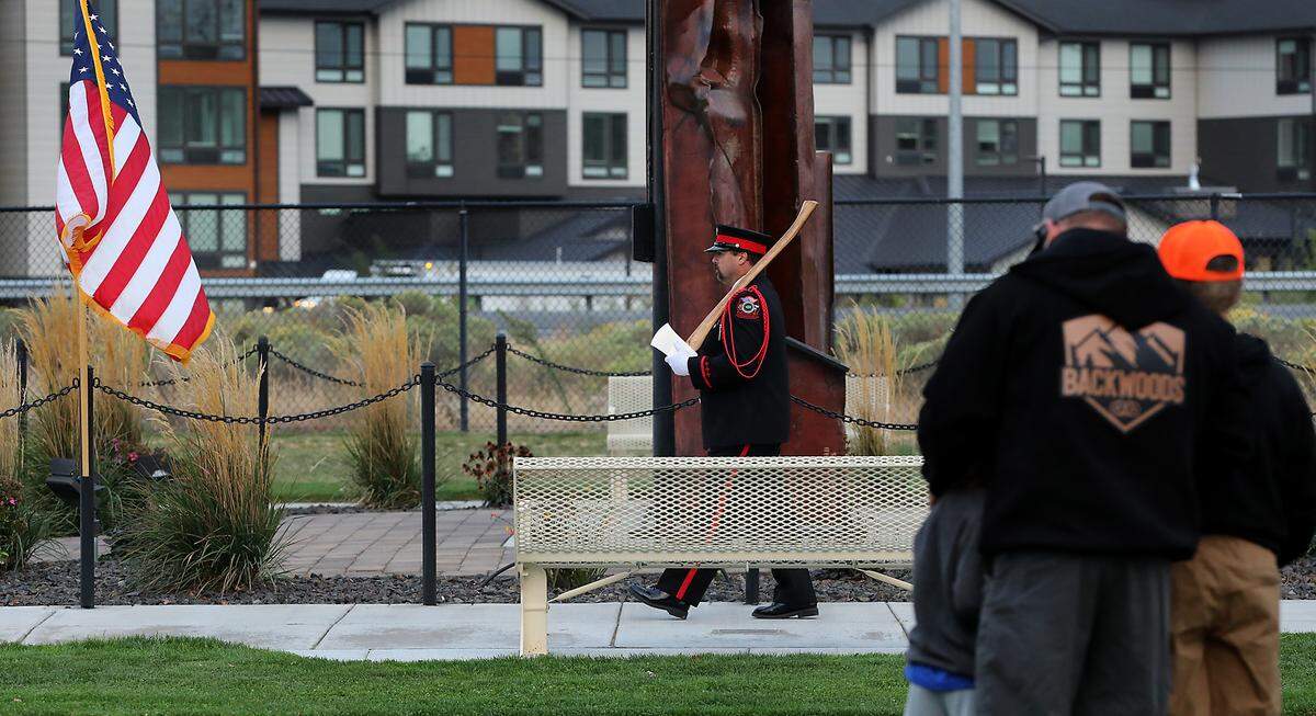 A father and his two sons watch as a member of the Tri-Cities Professional Firefighters Honor Guard marks the 24th anniversary of the Sept. 11, 2001, attacks Thursday morning at the 9-11-01 Memorial at Kennewick’s Southridge Sports & Events Complex.