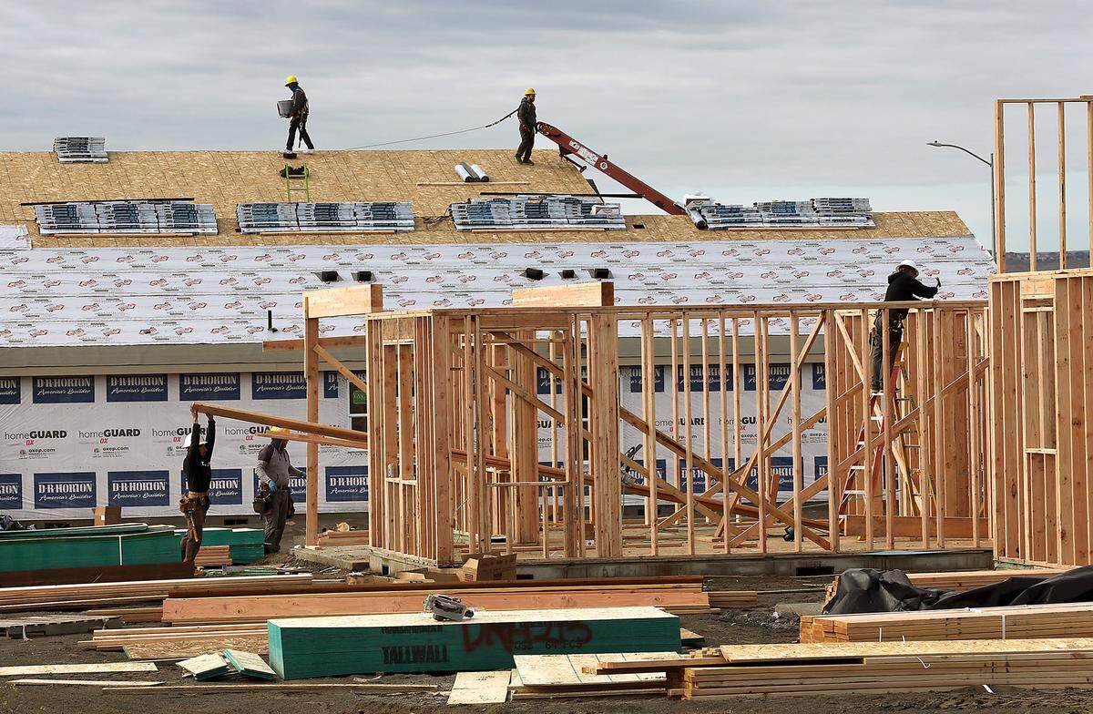 Construction crews work on new homes for sale on Road 115 in the The Dunes in west Pasco.