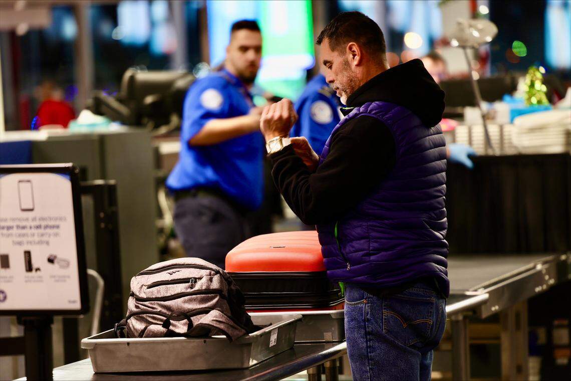 A passenger gathers his belongings after passing through the Transportation Security Administration screening station at the Tri-Cities Airport in Pasco early Monday morning, as the holiday travel season kicked into gear.