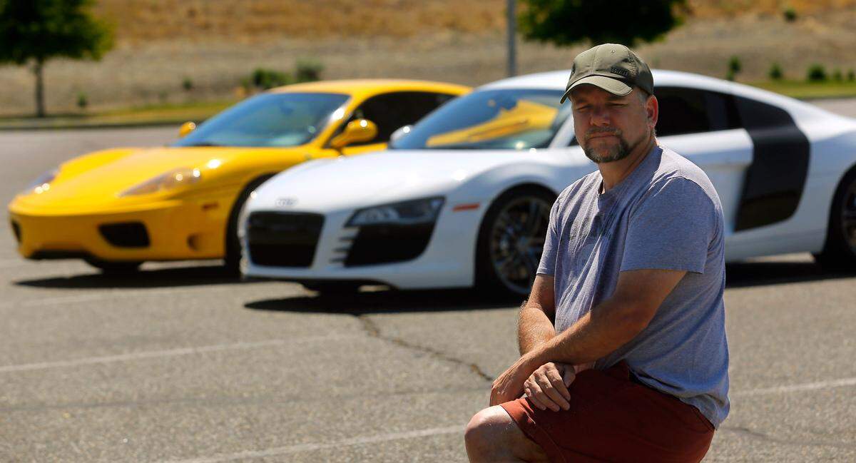 Steve Zetz of Benton City claims he and others were scammed by a business they paid to customize their vehicles. Behind Zetz are a friend’s yellow 1999 Ferrari 360 Modena and a 2020 Audi r8.