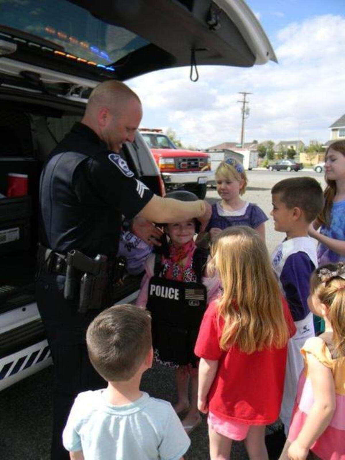 Officer Thomas Grego talks with kids at National Night Out in West Richland.