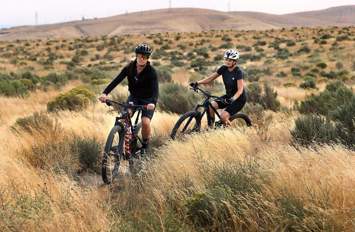 Mountain biking enthusiasts Julie Nelson, left, and Michelle Froh, both part of the Columbia Basin Chapter of the Evergreen Mountain Bike Alliance, ride on the trails on undeveloped land just south of Kennewick near the Washington State Patrol office. 