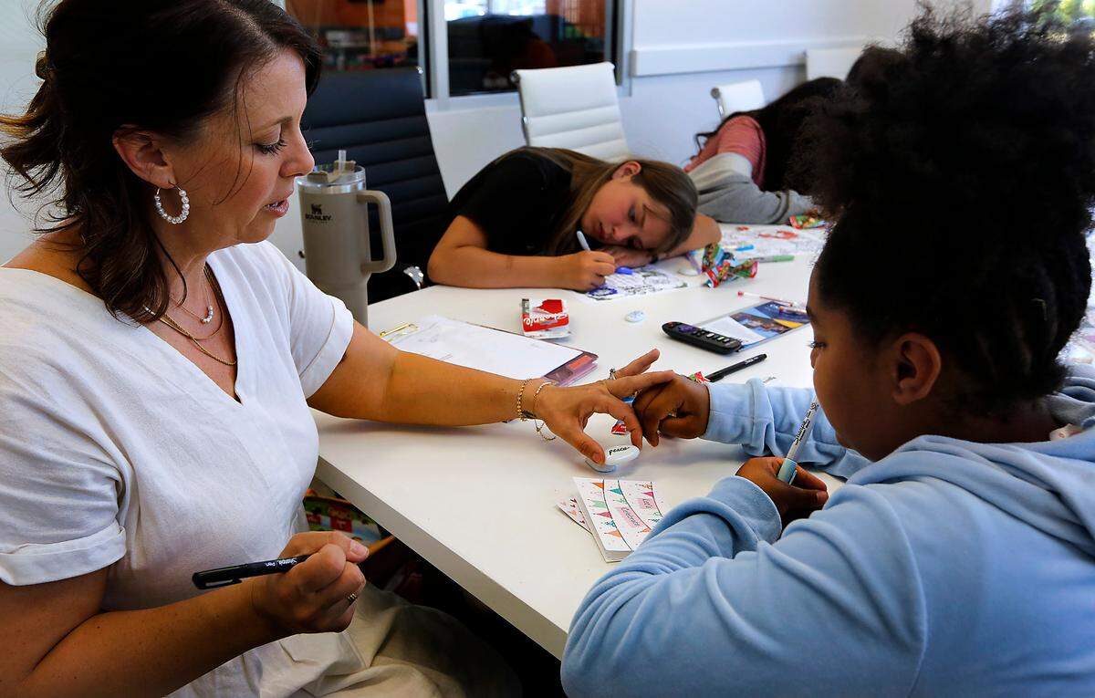 Jenny Vollmer, director of behavioral health, helps member McKenzie Sparks create a personalized “worry stone” during a meeting with a group of 5th and 6th grade girls at the Kennewick clubhouse for the Boys & Girls Clubs of Benton and Franklin Counties.