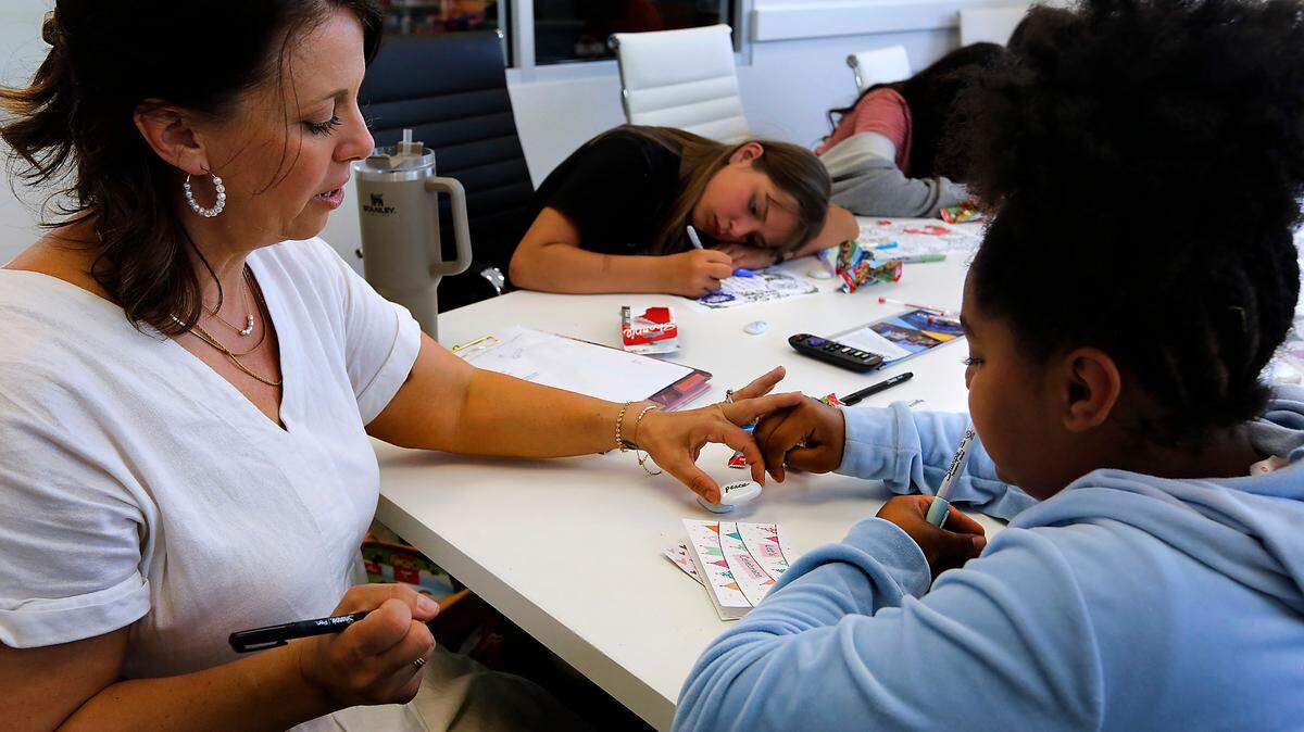 Jenny Vollmer, director of behavioral health, helps McKenzie Sparks create a personalized “worry stone” during a meeting with a small group of fifth and sixth grade girls at the Kennewick clubhouse for the Boys & Girls Clubs of Benton and Franklin Counties. 