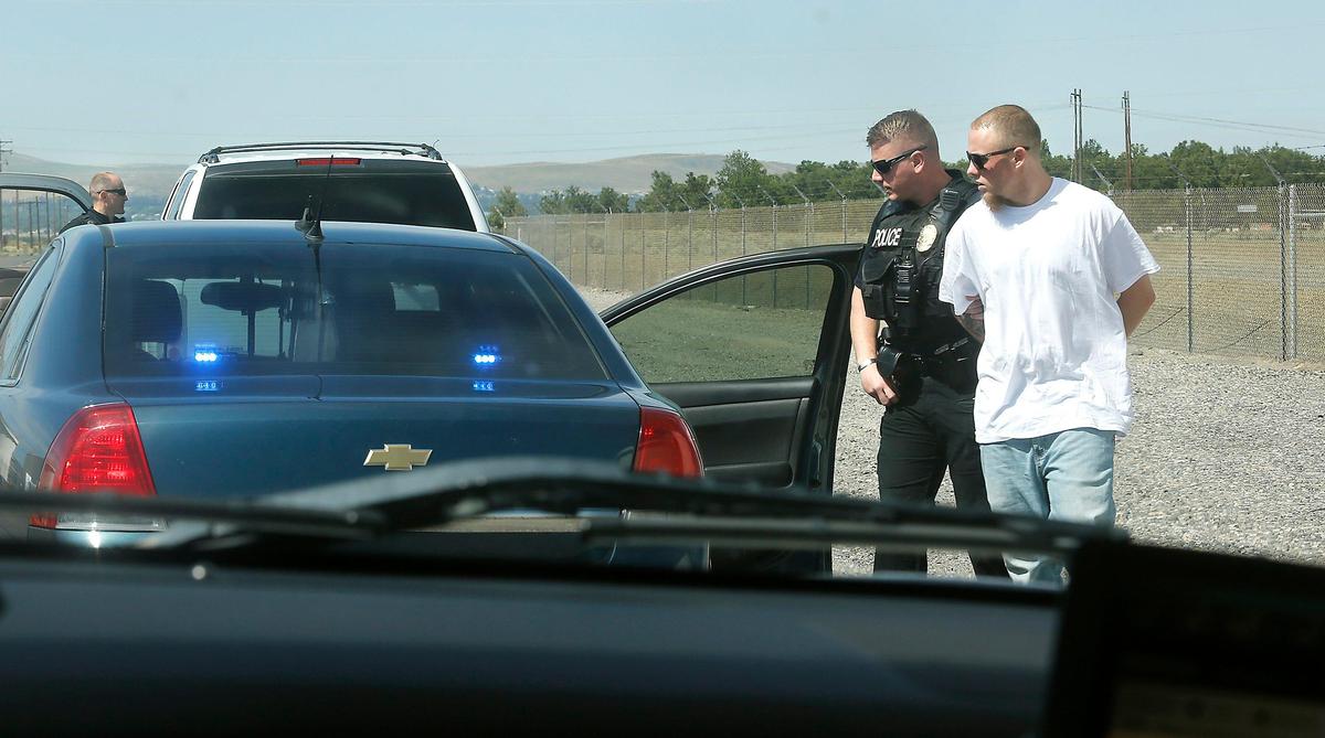 A member of the Kennewick Police Department Criminal Apprehension Team takes Travis Lee Harden into custody.