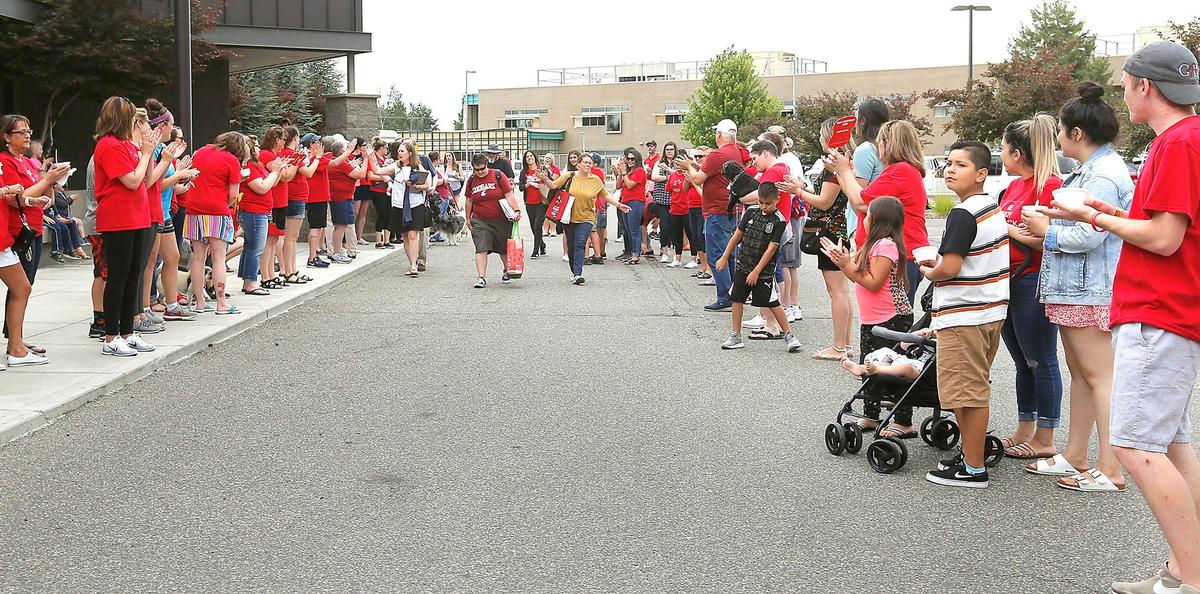 Members of the Kennewick Education Association bargaining team make their way through a group of teachers and supporters gathered for a rally Wednesday in the parking lot of the Kennewick School District administrative building on West Fourth Avenue. Watch a video at: tricityherald.com/video