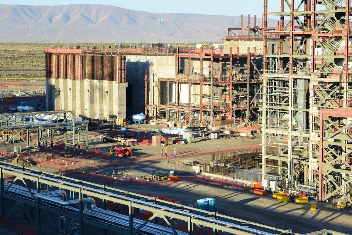 Employees walk between the High Level Waste Facility and the taller Pretreatment Facility at the vitrification plant in the center of the Hanford nuclear reservation.