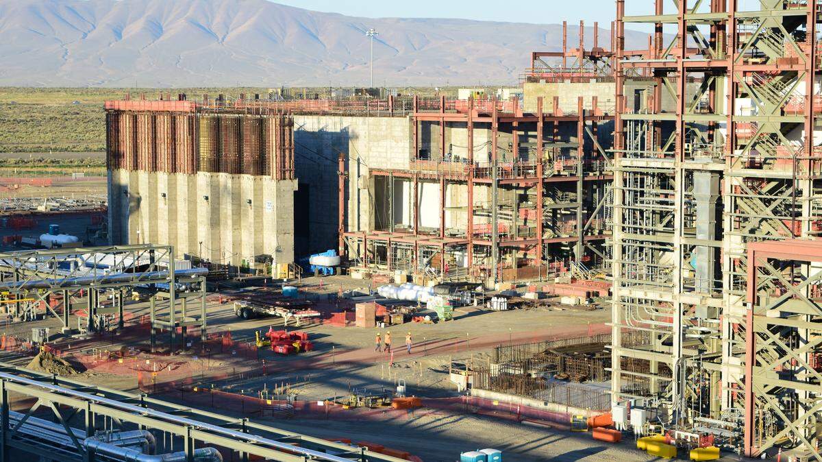 Employees walk between the High Level Waste Facility and the taller Pretreatment Facility at the vitrification plant in the center of the Hanford nuclear reservation.