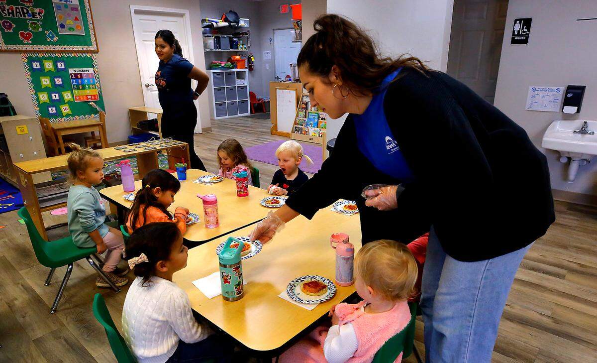 Level Up Learning teachers Jocelyne Neri, left, and Taylor Davis serve snacks to students in the preschool’s full-time program in Kennewick.