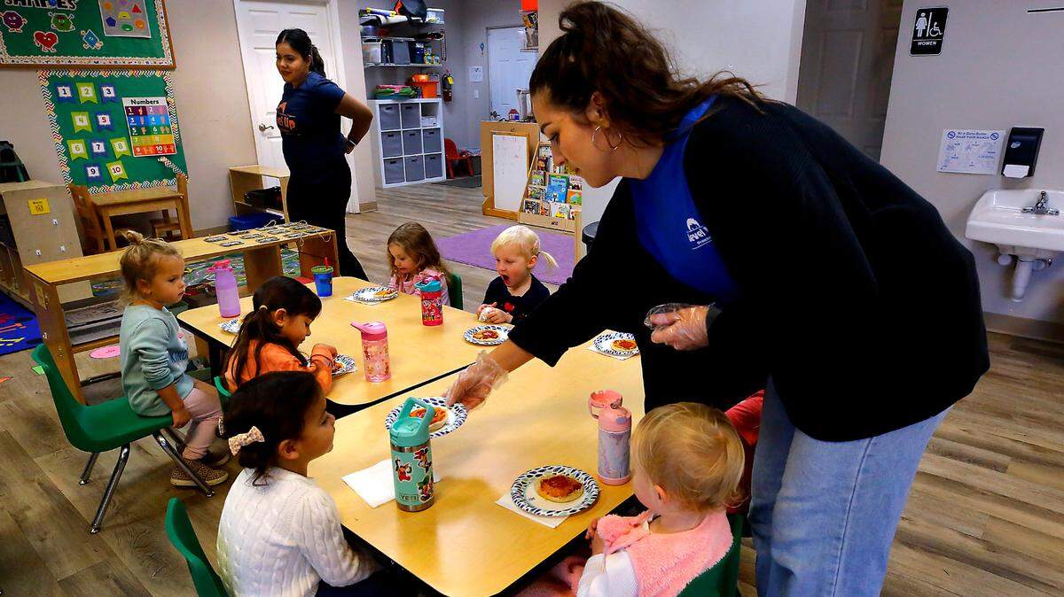 Level Up Learning teachers Jocelyne Neri, left, and Taylor Davis serve snacks to students in the preschool’s full-time program in Kennewick.