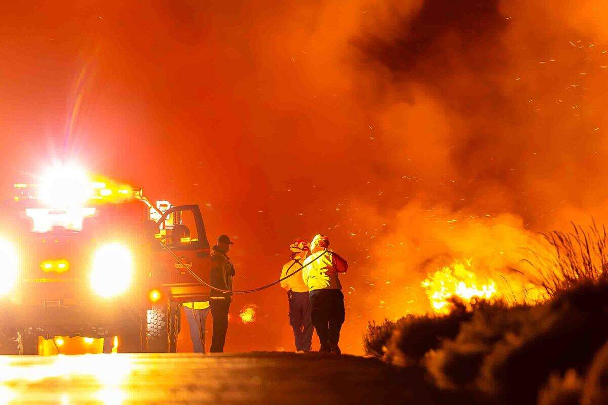 Firefighters battle the Nine Canyon Fire along South Nine Canyon Road early Saturday morning near Kennewick. Strong winds pushed the fast-moving wildfire northeast toward Finley, prompting evacuation notices and bringing in wildland strike teams from across the region.