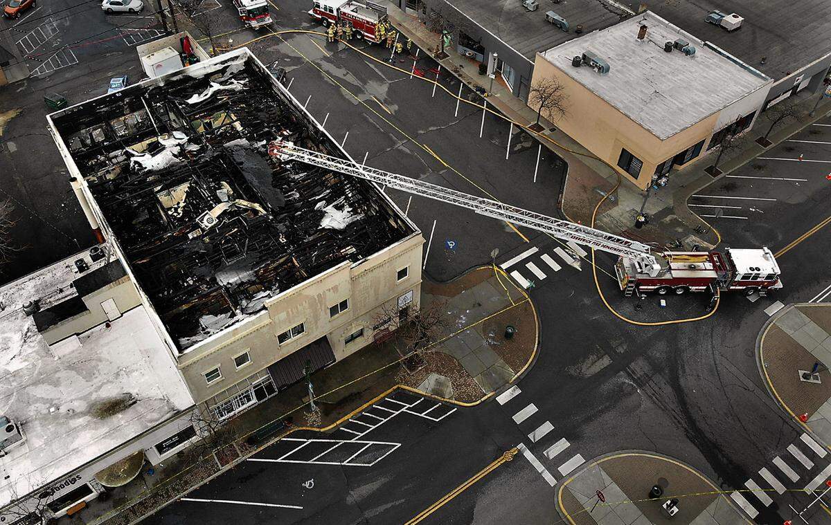 A Kennewick fire department ladder truck remains on the scene Friday afternoon after an early two-alarm fire in a historic downtown building at the corner of Kennewick Avenue and Cascade Street that damaged businesses and burned apartments. One person was taken to the hospital.