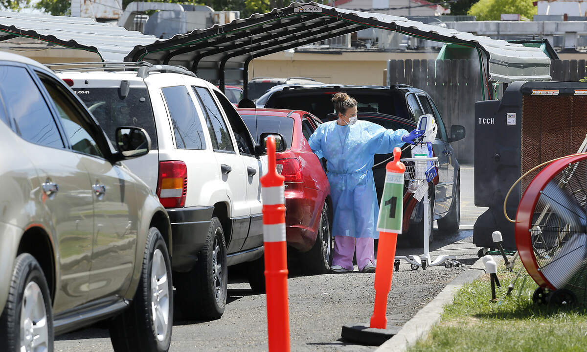 A nurse at the Tri-Cities Community Health at 515 W. Court St. checks the temperature of a patient in a car waiting in the drive-up coronavirus testing lanes at the Pasco facility. Watch video at: tricityherald.com/videos
