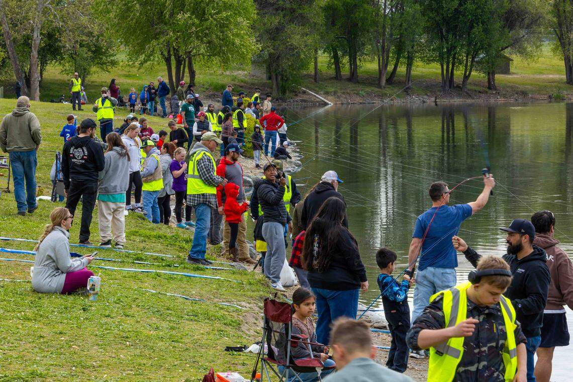 Families line the banks of Columbia Park Pond during Kids Fishing Day in Kennewick. More than 1,300 children participated in the annual event.