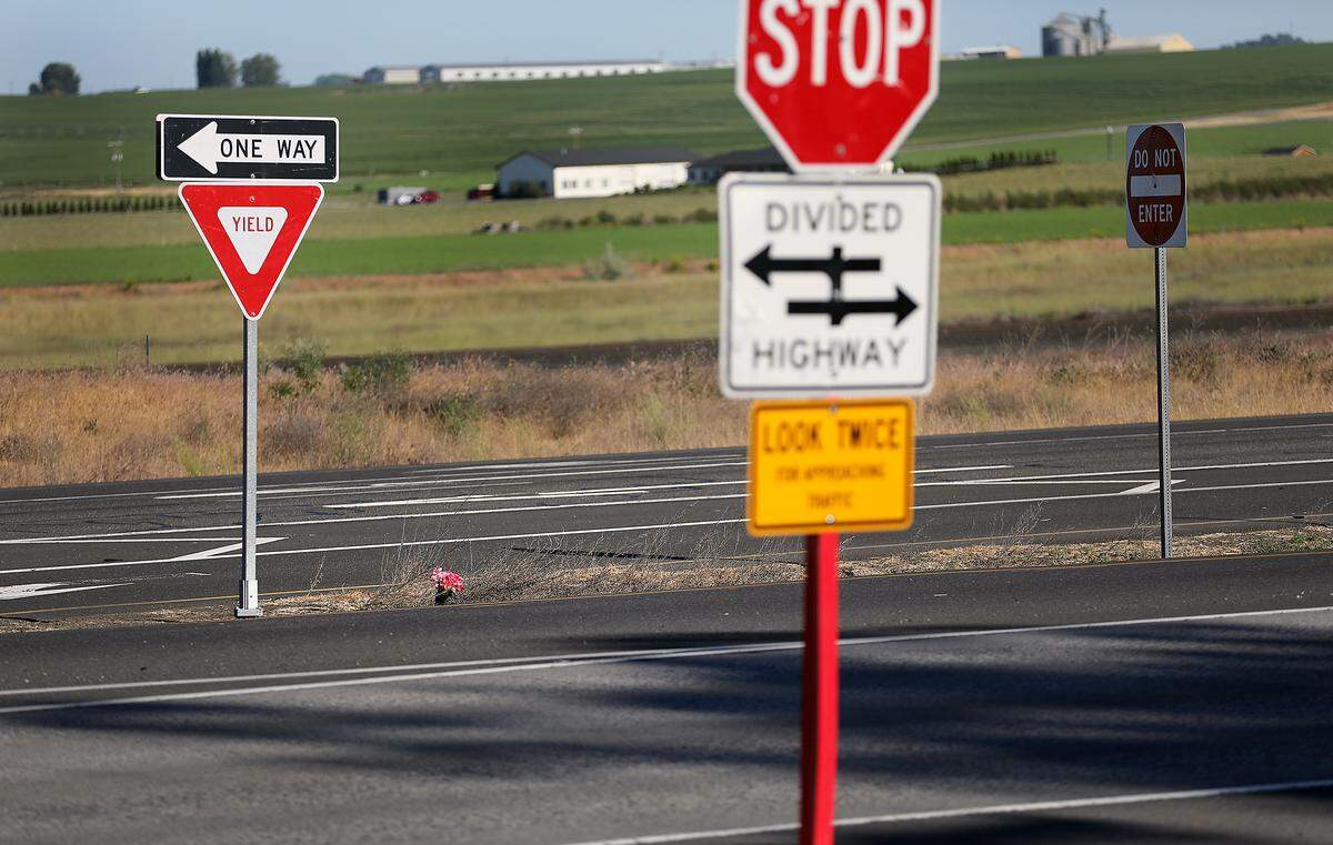 Flowers near the turn lanes on Highway 395 at Crest Loch Road north of Pasco memorialize victims of a fatal collision. 