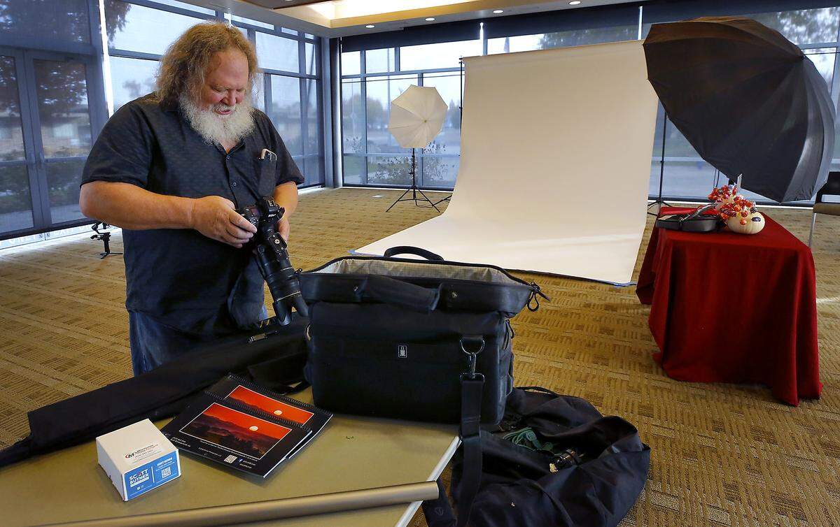 Photographer Scott Butner prepares his camera equipment to take free portraits of residents in their Halloween costumes Friday morning at the Richland Public Library. It's a tradition he's done for 16 years. 