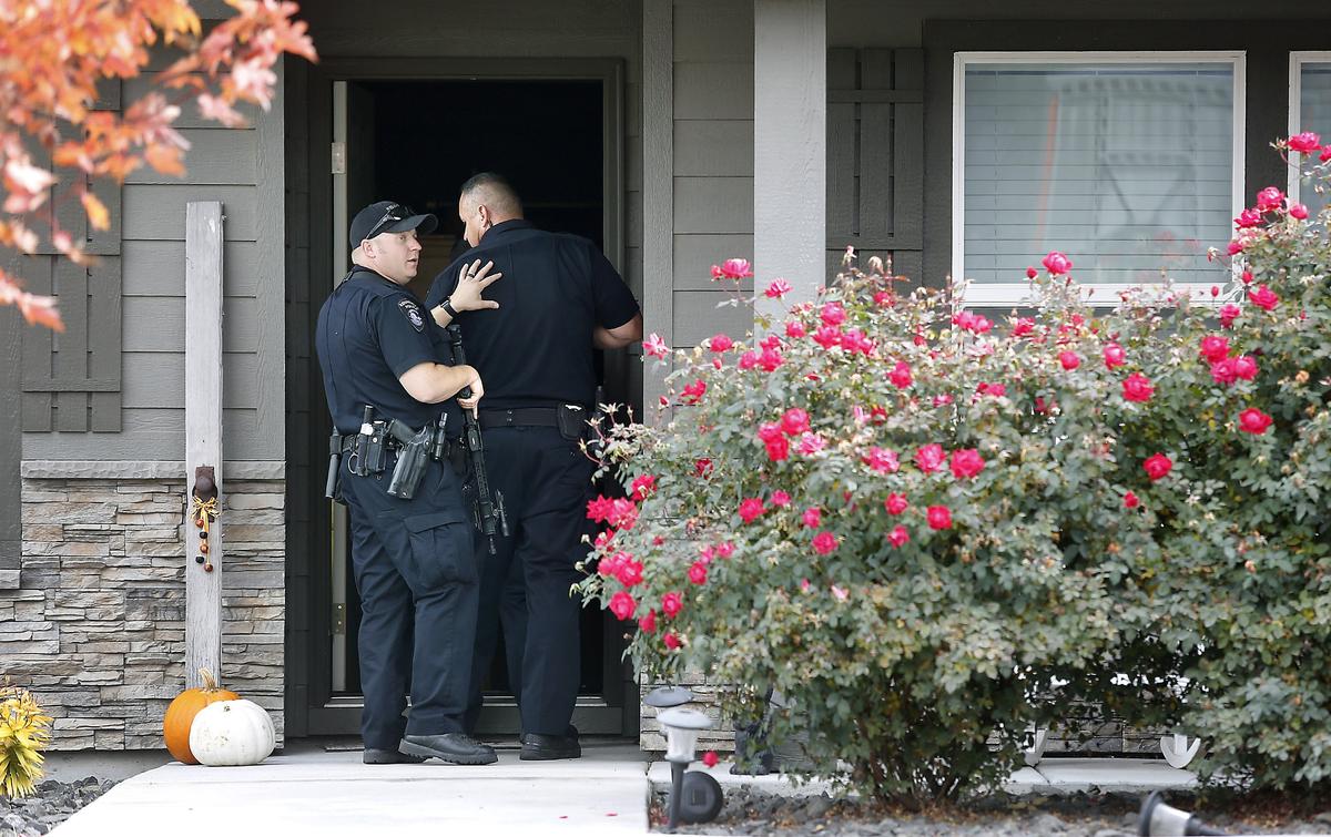 Kennewick police officers prepare to search inside a home in the 100 block of South Osborne Street Wednesday morning after apprehending two attempted burglary suspects nearby the residence. The homeowner called 911 after receiving an alert on her cellphone from a home security camera system that also provided a live video feed. Watch a video at: tricityherald.com/video