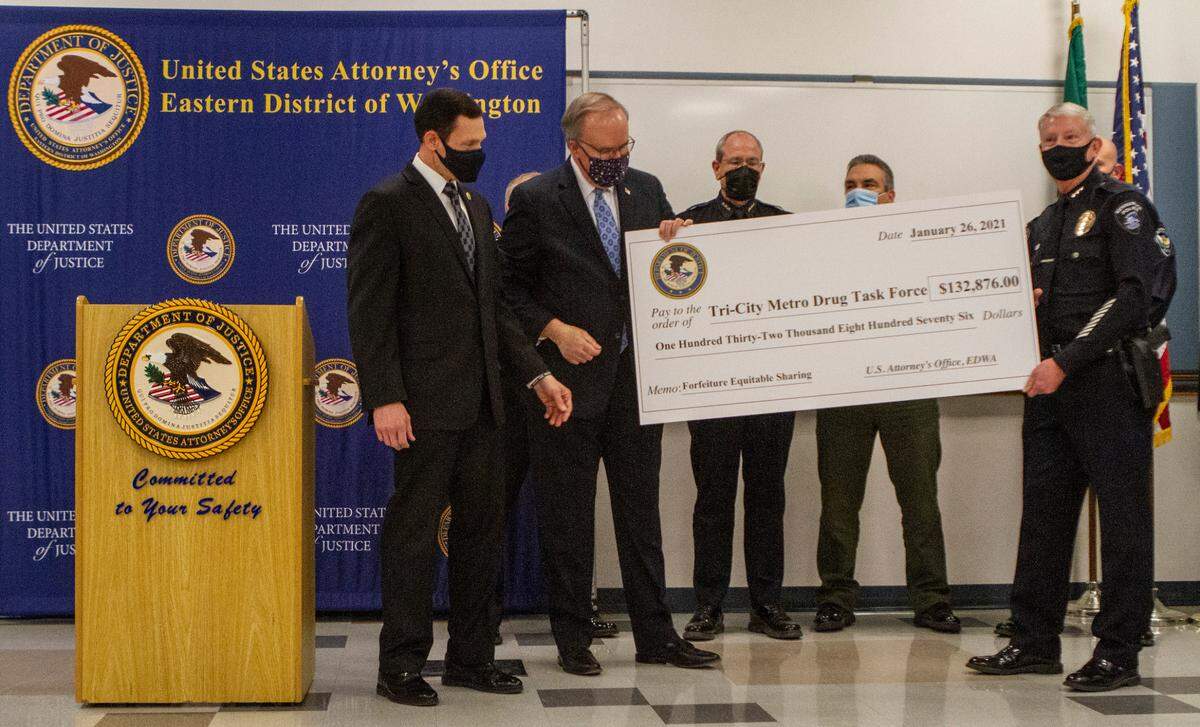United States Attorney William D. Hyslop and Drug Enforcement Administration Special Agent-In-Charge Frank A. Tarentino present Kennewick Chief of Police Ken Hohenberg and the Tri-City Metro Drug Task Force with a check for $132,876 as a forfeiture award as a result of Tri-City area Fentanyl-laced pill investigations.