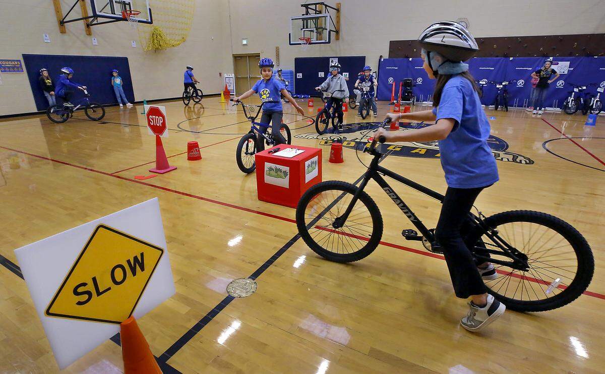Fifth-grade students participate in the Let’s Go bicycle education and safety program in the gym at Cascade Elementary School during Sue Swoboda’s PE class.