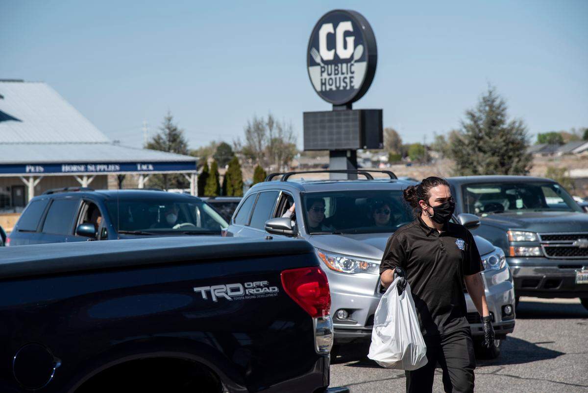 Salvador Gonzalez, 20, of Kennewick, takes orders to patrons during the drive-up asparagus festival held at in the parking lot of the CG Public House restaurant in Kennewick.