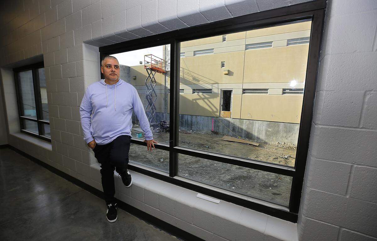 Rudy Ruelas, manager at the justice center, stands inside the Kennewick facility with a view of the outdoor rec area under construction.