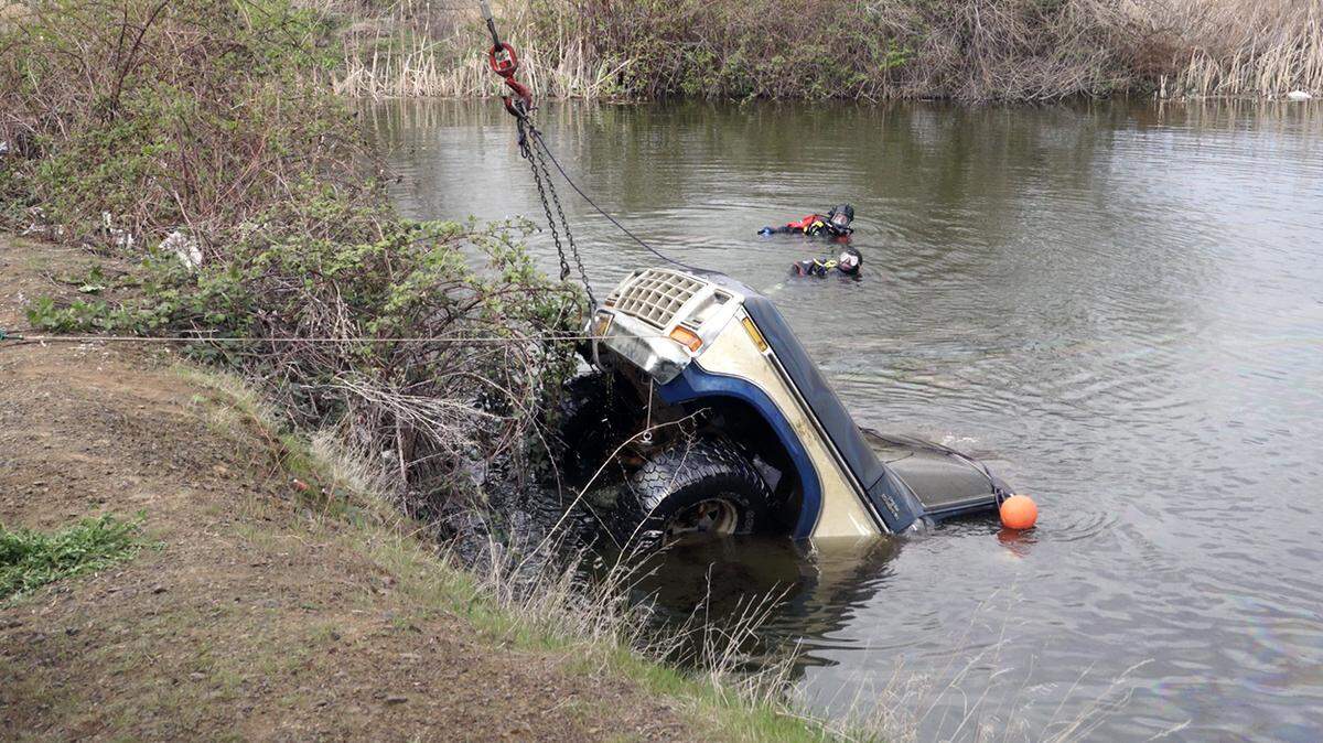 Volunteer divers from Oregon Dive and Rescue look on as Eastern Oregon Towing pulls a 1979 Ford F-150 out of Johnley Pond on April 12.