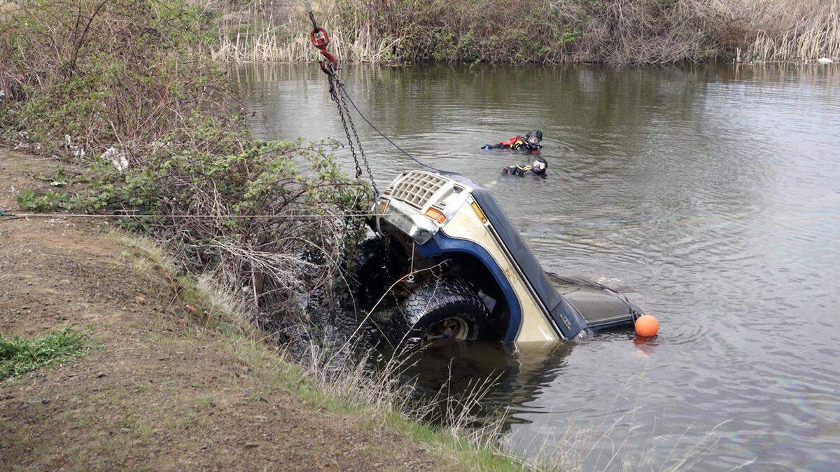Volunteer divers from Oregon Dive and Rescue look on as Eastern Oregon Towing pulls a 1979 Ford F-150 out of Johnley Pond on April 12.
