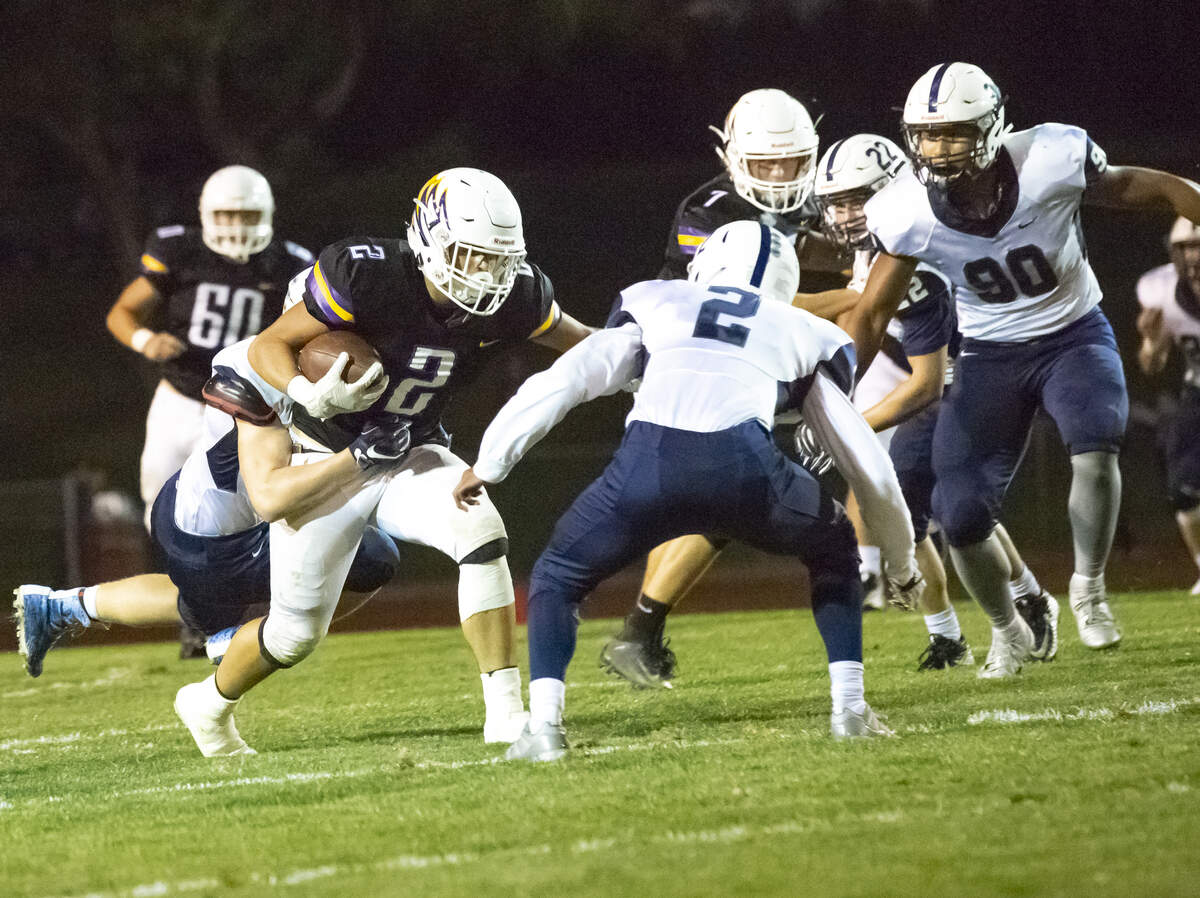 Hanford’s Kaden Harper Lee (2) runs while trying to escape Chiawana’s Dion Lee (2) during a Mid-Columbia Conference high school football game at Fran Rish in Richland on Friday. Hanford defeated Chiawana 34-21.