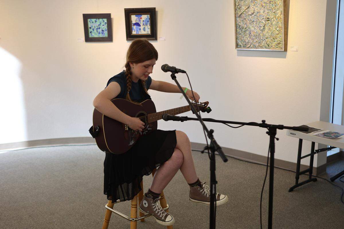 Local 18-year-old Gwen Good tunes her guitar between songs during her set at Gallery at the Park through Tri Town Get Down on June 7.