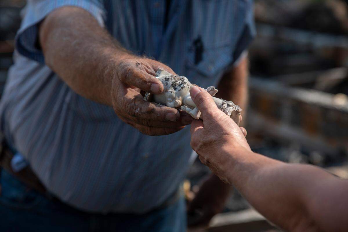 Dairy farmers Lavonne and Jim Boogerd sift through the charred remains of their home which burned down during a fire that burned nearly 800 acres in Prosser on Labor Day.
