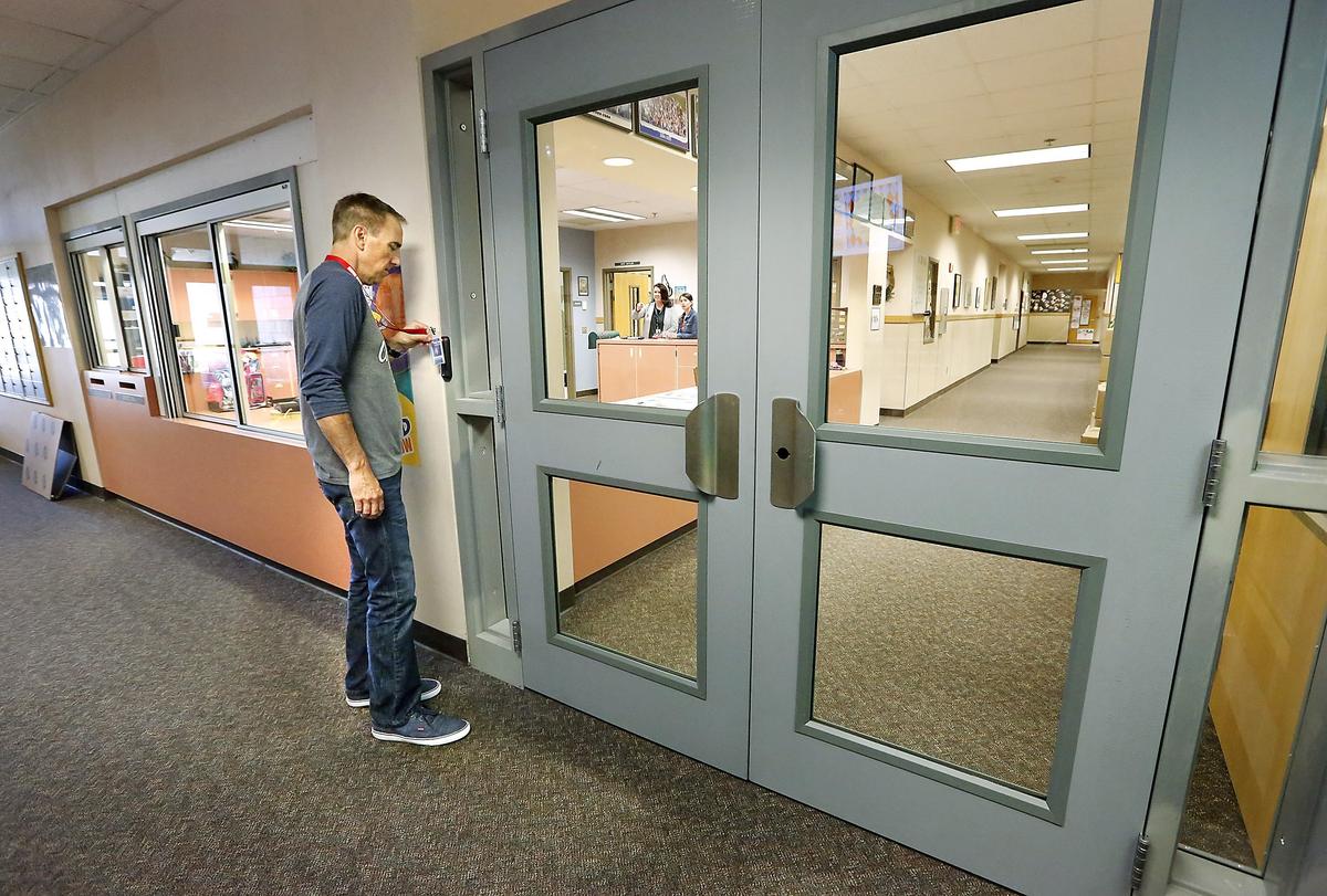 Counselor Scott Pflieger uses his Kennewick School Disrict identification badge to unlock one of two new sets of security doors recently installed near the office at Ridge View Elementary School in Kennewick. The district is making a variety of changes at its elementary school to improve safety. Watch a video at: tricityherald.com/video