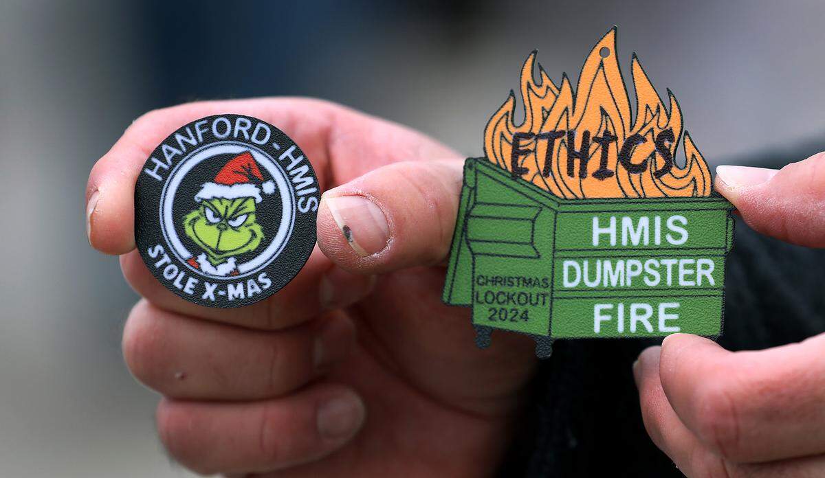A Hanford guard member holds a plastic coin and Christmas tree ornament he created with a 3D printer during their lock out from the Hanford site. Members of the Hanford Guards Union Local 21 picketed on Dec. 11, 2024, near John Dam Plaza in Richland.