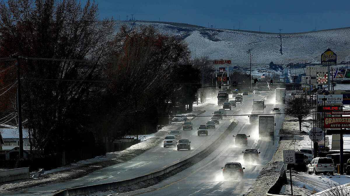 Spray created from melting snow is kicked up by traffic on Highway 395 and increasingly gusty southwest winds Friday as temperatures climbed into the mid-40s.