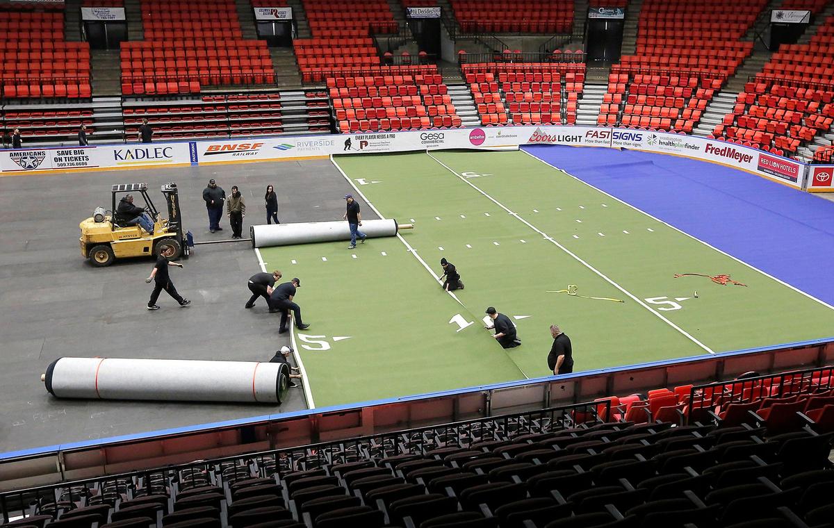 Workers inside the Toyota Center unroll the former Tri-Cities Fever turf football field earlier this year as the launch of a new professional indoor football called the Tri-Ciies Fire was announced in Kennewick.