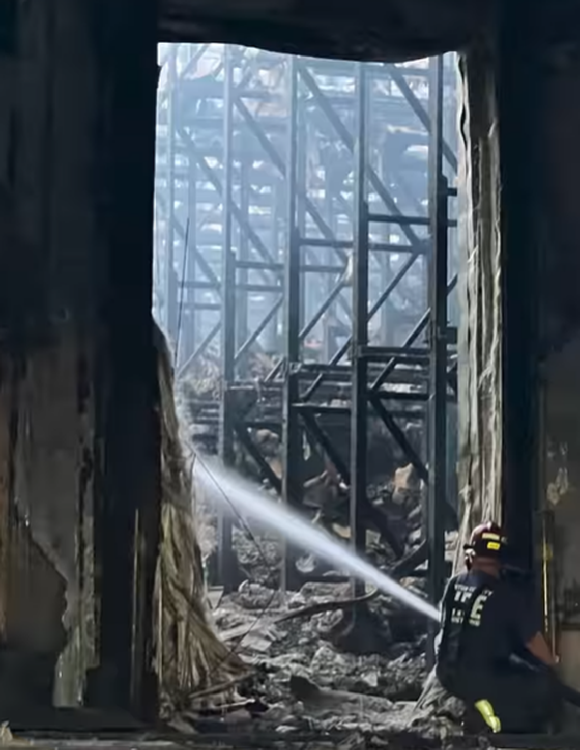A firefighter sprays water on what remains of the Kennewick Lineage cold storage warehouse in Finley.